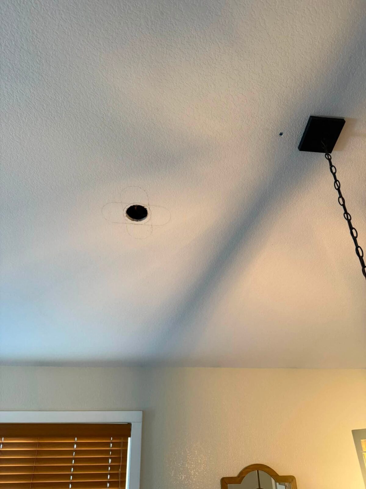 Open hole cut into a textured vaulted ceiling before repair